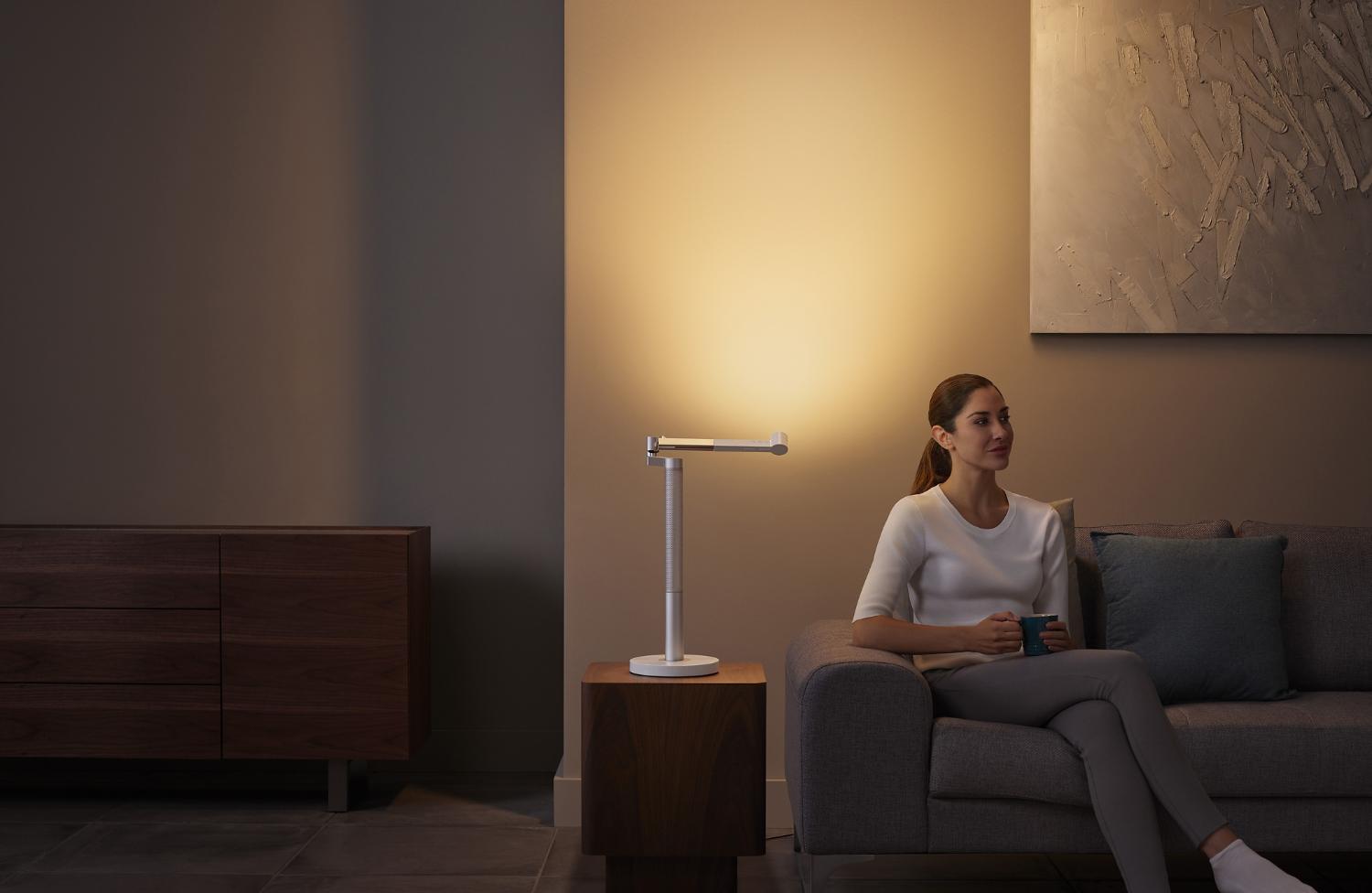 Woman basking in the glow of the Dyson Lightcycle Morph light